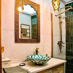 Cuisine et salle de bain avec des produits du Mexique | Dans cette salle de bain, la vasque à poser, peinte à la main au Mexique, ajoute une touche exotique et unique. La couleur verte et le motif soigneusement travaillé créent un ensemble harmonieux, ajoutant un charme unique à l'espace.